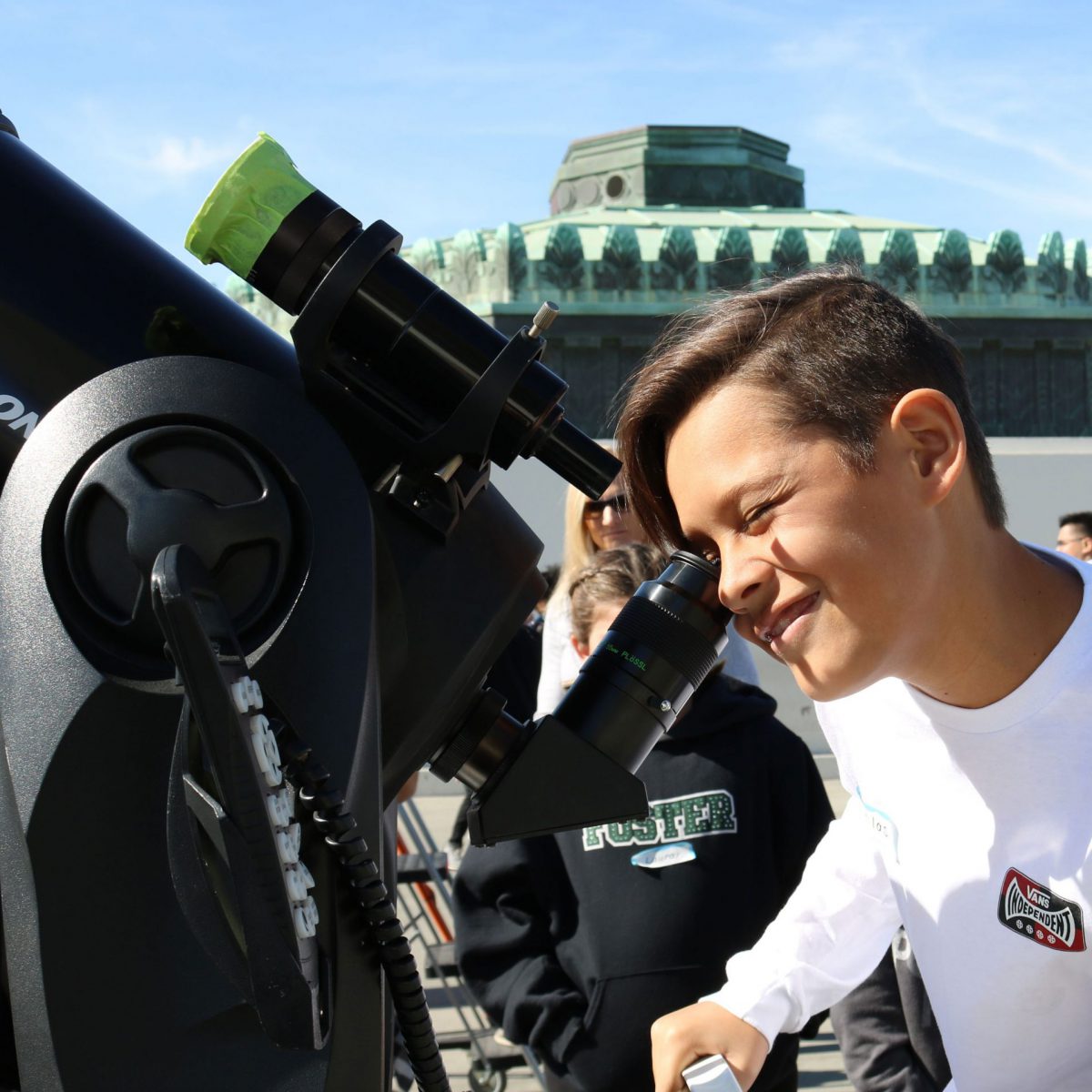 A boy looks through a telescope at Griffith Observatory.