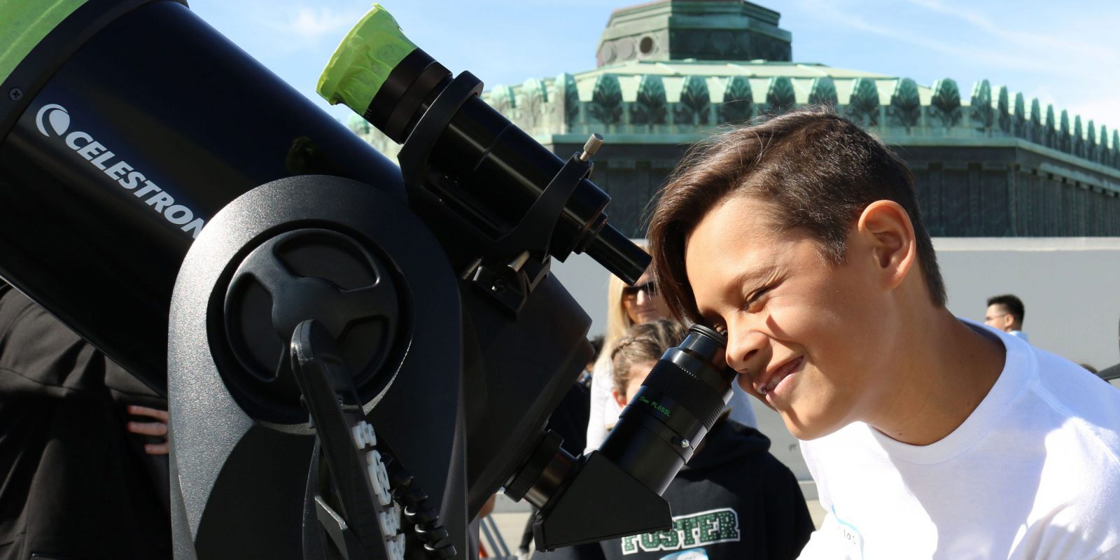 A boy looks through a telescope at Griffith Observatory.