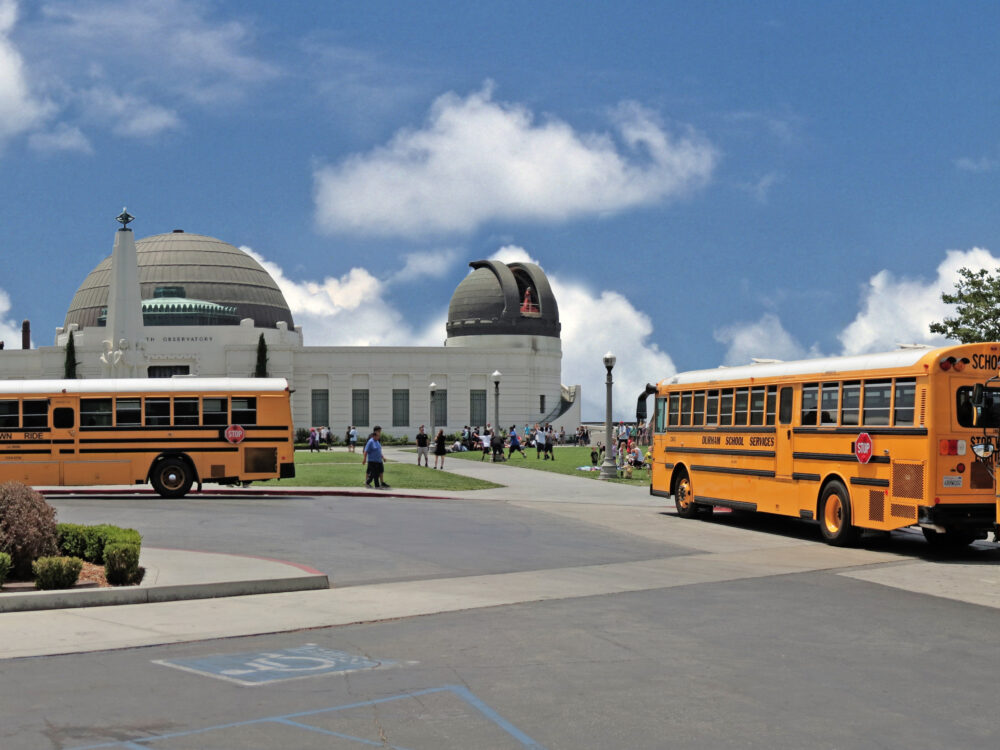 Three yellow school buses in front of Griffith Observatory.