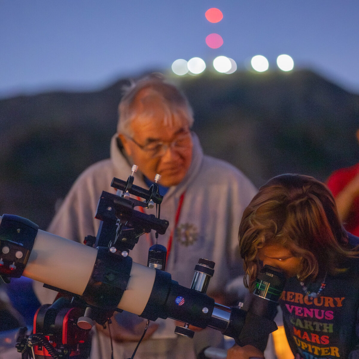 A child looks through a lawn telescope.