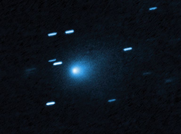 Blurry bluish white dashes and a fuzzy orb against a dark background.